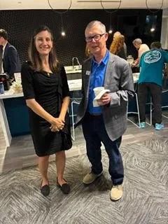 Two professionals smiling at a networking reception