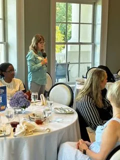 Speaker addressing a seated group at a networking lunch event